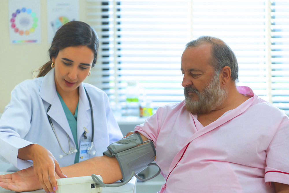 Médica aferindo a pressão arterial de um paciente idoso em uma consulta, ilustrando o acompanhamento médico para monitorar a saúde cardiovascular e prevenir complicações.