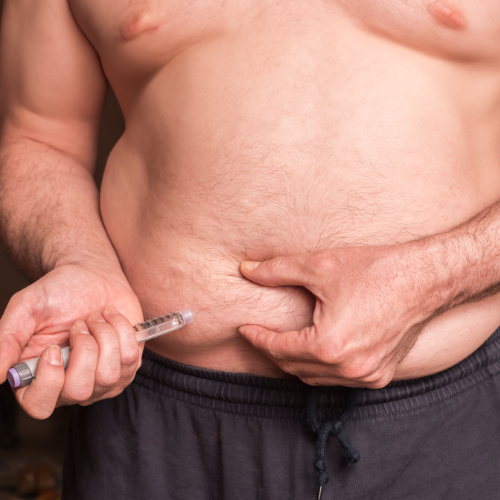 Pessoa aplicando caneta injetável na região abdominal